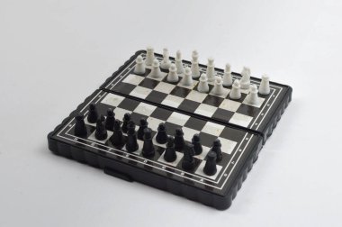 Temiz bir stüdyo ortamında seyahat, pratik ve masa üstü oyunu için ideal klasik bir strateji oyunu için zıt taşları olan kompakt katlanabilir bir satranç tahtası.