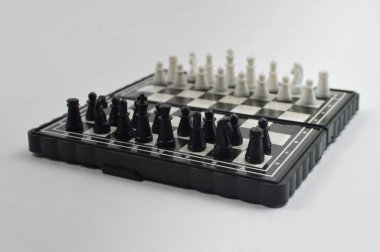 Temiz bir stüdyo ortamında seyahat, pratik ve masa üstü oyunu için ideal klasik bir strateji oyunu için zıt taşları olan kompakt katlanabilir bir satranç tahtası.