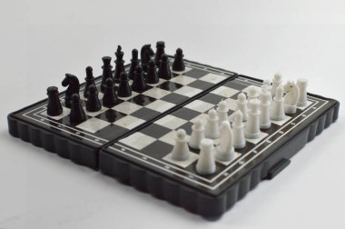 Temiz bir stüdyo ortamında seyahat, pratik ve masa üstü oyunu için ideal klasik bir strateji oyunu için zıt taşları olan kompakt katlanabilir bir satranç tahtası.