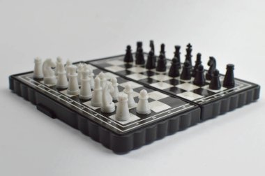 Oyun için zıt oyun taşları düzenlenmiş klasik satranç tahtası, stratejiyi, rekabeti, zekayı ve masa oyunları ve zihin sporları temalarını sembolize ediyor..