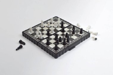 Klasik bir masa oyunu konseptinde strateji, planlama, rekabet ve mantıksal düşünceyi temsil eden dağınık parçalı katlanabilir satranç tahtası.