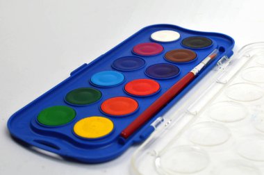 Canlı yuvarlak renkler ve küçük bir fırça ile suluboya palet, bir stüdyo ortamında sanat pratiği, yaratıcılık ve resim faaliyetleri için uygundur.