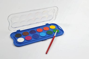 Portatif suluboya paleti parlak dairesel renkler ve fırça, resim, sanat pratiği, yaratıcılık ve sanatsal faaliyetler için ideal temiz bir stüdyo ortamında.