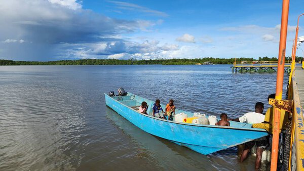 Papuan locals cross the sea in a wooden boat near coastal Papua, Indonesia. Daily transportation between islands. Captured on June 28, 2025.  Papua, Indonesia