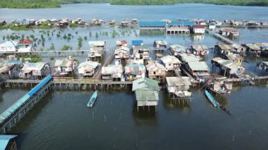 Papua 'nın gelgit sularının üzerindeki canlı bir stilt köyü. Karaka Adası sakinleri, güçlü kıyı kültürü ve geleneksel ada yaşamını yansıtan günlük hareketlilik için teknelere ve ahşap köprülere güveniyor.