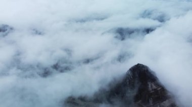 Grasberg, Papua 'da yoğun sis ve dağ sisi içinde dönen bir maden yolunun hava manzarası.
