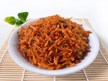 Kentang Mustofa, Endonezya gevreği ve baharatlı patates çubukları bambu hasırında servis edilir. Yemek temaları, reklamlar ve mutfak sunumları için ideal..