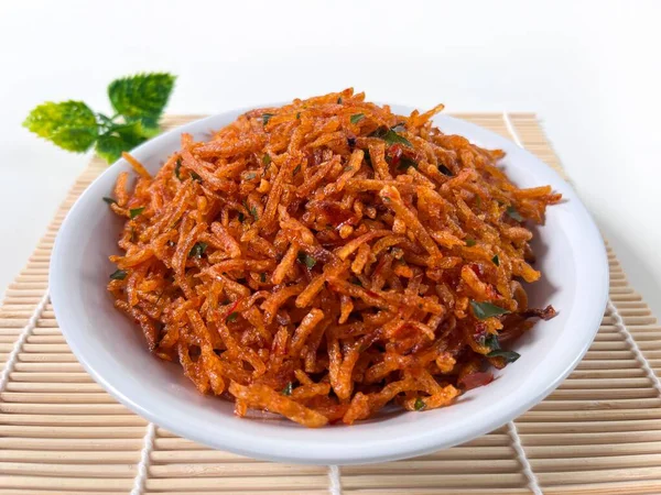 Kentang Mustofa, Endonezya gevreği ve baharatlı patates çubukları bambu hasırında servis edilir. Yemek temaları, reklamlar ve mutfak sunumları için ideal..