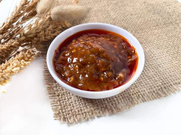 Sambal Goreng, bembeyaz bir kasede servis edilen baharatlı kırmızı biber sosu. Zengin dokuyu, canlı rengi ve geleneksel Endonezya çeşni tarzını gösteriyor.