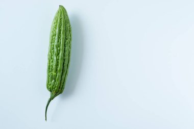 Tek, büyük, taze, yeşil, sert bir kavun. Eşsiz engebeli dokusu keskin bir odak noktasında, saf beyaz bir arka plana vurgulanmış, sağlıklı yiyecek, sebze ve yemek temaları için mükemmel..