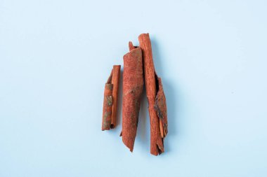 Beyaz arka planda üç desenli tarçın çubuğu, gıda ambalajı, mevsimsel tasarım veya bitkisel eğitim görselleri için mükemmel.