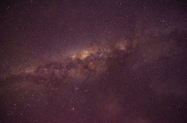 Görkemli Samanyolu galaksisi, yıldızlarla dolu açık bir gece gökyüzünü gösteren Endonezya 'nın bir manzarasının üzerinde döner. Seyahat, astrofotoğrafçılık ve doğa temaları için mükemmel..