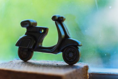 Seçici odak, altın Vespa scooter anahtarlığının makro çekimi. Bu küçük, detaylı kopya klasik bir tasarım içeriyor. Üstü kapalı, klasik ulaşım ve nostalji ruhunu yansıtıyor.. 