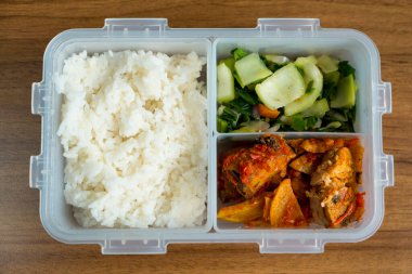 İçinde buharda pilav, baharatlı Mackarel ton balığı ve yanında kızarmış sebze bulunan Endonezya beslenme çantası. Sağlıklı, renkli ve lezzetli bir yemek..