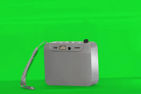 Taşınabilir gri bir bluetooth hoparlörü, USB, AUX, mikro SD ve yükleme portlarını gösteriyor.