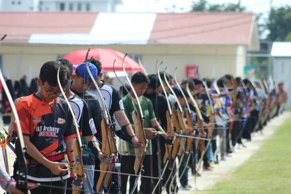 Banda Aceh, Endonezya - 8 Kasım 2025: Bir grup genç okçu açık hava okçuluğu sırasında ahşap yaylarını mükemmel bir şekilde hizalamaya çalışıyor