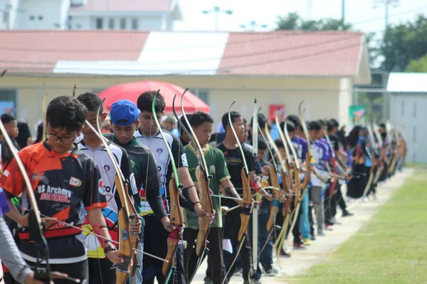 Banda Aceh, Endonezya - 8 Kasım 2025: Bir grup genç okçu açık hava okçuluğu sırasında ahşap yaylarını mükemmel bir şekilde hizalamaya çalışıyor