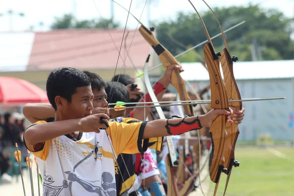 Banda Aceh, Endonezya - 8 Kasım 2025: Bir grup genç okçu açık hava okçuluğu sırasında ahşap yaylarını mükemmel bir şekilde hizalamaya çalışıyor