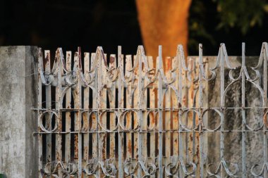 Köhne ve yıpranmış dokusu olan eski model metal çitler.