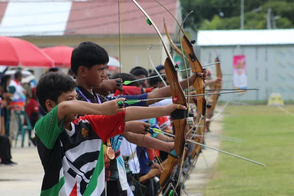 Banda Aceh, Endonezya - 12 Aralık 2025: Bir grup genç okçu, okçuluk eğitimi sırasında ahşap yaylarını mükemmel bir şekilde hizalamaya çalışıyor