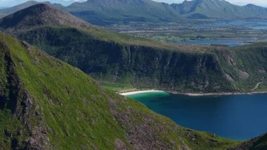 Norveç 'in Lofoten Adaları' ndaki güzel beyaz kumsal Haukland plajını çevreleyen yeşil dağlar nefes kesici bir manzara yaratıyor.