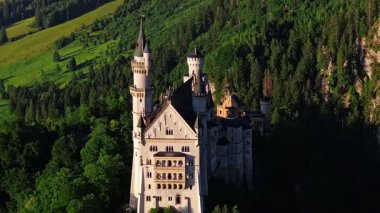 Neuschwanstein Şatosu, 19. yüzyıldan kalma bir Roma diriliş sarayı, güneybatı Bavyera, Fussen yakınlarındaki Hohenschwangau köyünün üzerindeki engebeli bir tepenin üzerinde yer alır.