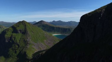 Kuzey Norveç 'in sakin yaz günü boyunca Kuzey Norveç' teki Senja Adası 'nın el değmemiş doğal güzelliğini gözler önüne seren Hovsfjorden ve Segla Dağları' nın engebeli manzarası ılık güneş ışığı banyosu.