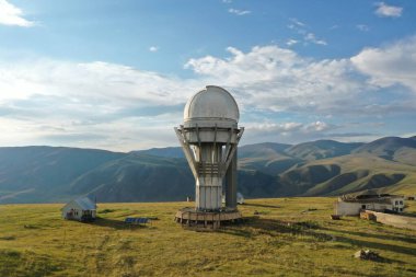 Yeşil tepeler ve açık gökyüzü ile çevrili uzak bir dağda geniş bir optik teleskop kubbesi olan kıç-türgen gözlemevi astronomi, araştırma ve keşif çağrıştırıyor.