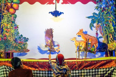 Yogyakarta, 11 Ekim 2025. Genç bir kuklacı wayang kancil (geyik kuklası) oynar. Wayang Kancil bir tür gölge kuklasıdır ve ana karakterleri hayvanlardır, özellikle de fare geyikleridir..