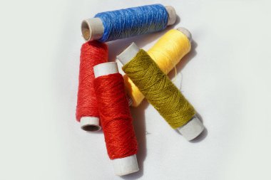 Birçok renkli dikiş iplikleri beyaz arka plana düşüyor. Arkaplan ve soyut görüntü. Boşluğu kopyala.