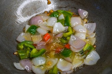 Şef 'in el aşçısının ellerini kapat ve Asya mutfağı için fırında pişmiş sebzeleri fırına at. Uçan yiyecek havalanması.