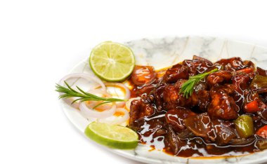 Biberli tavuğa yakın, Kore usulü kızarmış biberli tavuk Hindistan 'da evde yapılmış, soğan ve limonla servis edilmiş beyaz arka planda.