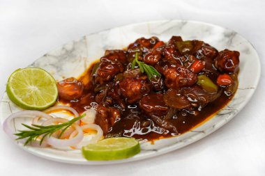 Mançurya usulü tavuk ya da acı biberli tavuk, beyaz arka planda izole edilmiş kırmızı sıcak ve baharatlı köri. Tavuk göğsü, dolma biber, domates ve soya soslu Hint Çin yemeği..