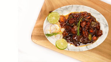 Mançurya usulü tavuk ya da acı biberli tavuk, ahşap arka planda izole edilmiş kırmızı sıcak ve baharatlı köri. Hint Çin mutfağı ve tavuk göğsü. Seçici odak ve kopyalama alanı.