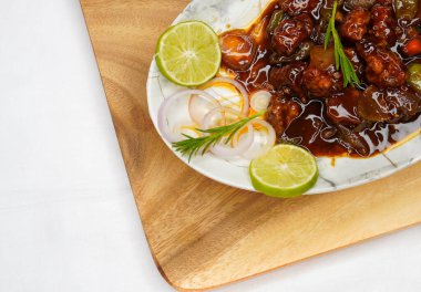 Mançurya tavuğu ya da acı biberli tavuk, Kore usulü kızarmış biberli tavuk Hindistan 'da evde yapılmış, ahşap bir tabakta servis ediliyor.