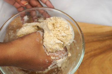 Kadınlar tarafından hazırlanmış hamur tatlısı. Fırında kadın elleriyle hamur topluyor. Yemek konsepti. Beyaz arkaplan.