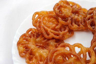 Bir tabakta Imarti Jalebi 'nin yakın çekimi, Hindistan' da yaygın olarak kullanılan en lezzetli tatlılardan biridir. Taze jalebi. Yağ veya yağ ile kızartılmış şeker şuruplu tatlı bir Hint tatlısı..