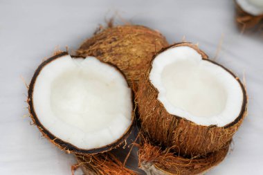 Beyaz arka planda izole edilmiş taze hindistan cevizi. Soyulmuş ve dağınık hindistan cevizi lifleri. Seçici odak.