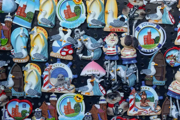 Martılar, deniz fenerleri, denizciler, çapalar ve plaj motifleri bir hediyelik eşya standında sergilenen Ustka temalı buzdolabı mıknatıslarının canlı koleksiyonu. Mükemmel Polonya kıyısı hatıraları.
