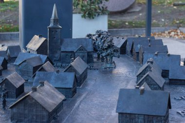 Kilise kulesi ve turizm kültürü ve tarihi eğitim için açık havada sergilenen evleri olan bir ortaçağ kasabasının ayrıntılı bronz maketi.