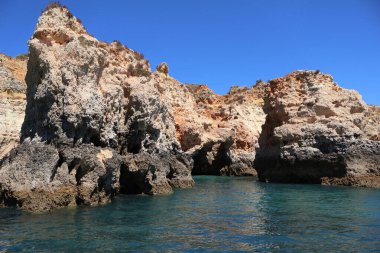 Çarpıcı kayalıklar ve deniz mağaraları tekne turları ve geziler için popüler bir yerdir.