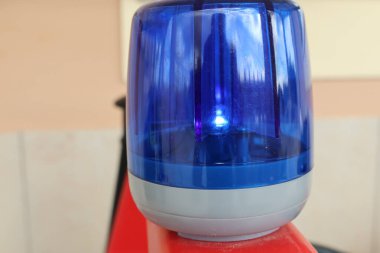 Bu görüntü, muhtemelen bir araç ya da bina için tarafsız bir arkaplanda mavi bir acil durum ışığı gösteriyor.