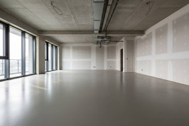 Bu geniş iç mekan doğal ışık sunan beton tavanlar, alçıpan ve geniş pencerelere sahiptir.