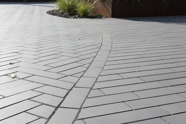 Bu resim, benzersiz tuğla desenli ve stil eğimli bir yol ile çağdaş bir dış mekanı gösteriyor.