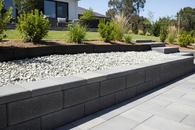 Bu resim doğal elementler ve çağdaş mimariye odaklı güzel tasarlanmış bir dış mekanı gösteriyor.