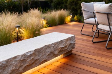 Ilık aydınlatma modern bir dış mekanı aydınlatır, eğlendirici ve davetkar bir atmosfer yaratır.