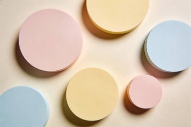 Yumuşak pastel renkte dairesel şekillerin bir derlemesi, düz bir arkaplan karşısında görsel olarak hoş bir kompozisyon düzenlenmiştir.