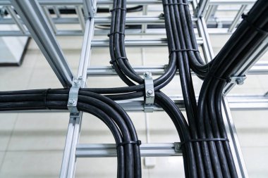 Endüstriyel alüminyum destek yapısında düzgün düzenlenmiş güç kablolarının ve veri hatlarının yakın görüntüsü