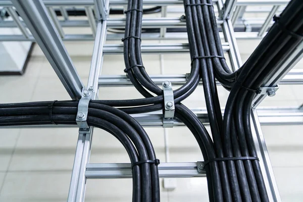 Endüstriyel alüminyum destek yapısında düzgün düzenlenmiş güç kablolarının ve veri hatlarının yakın görüntüsü
