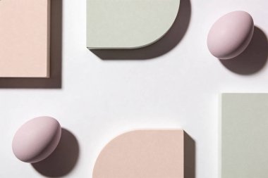Pastel renkli geometrik formlar ve oval nesnelerin temiz ve modern bir düzenlenmesi, sakin ve soyut bir görsel oluşturur.